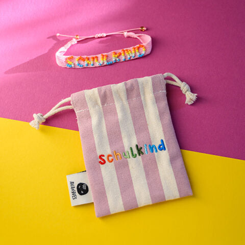 Gewebtes Armband mit handgearbeiteter Stickerei Schulkind in rosa, mit Säckchen dunkles rose/weiß